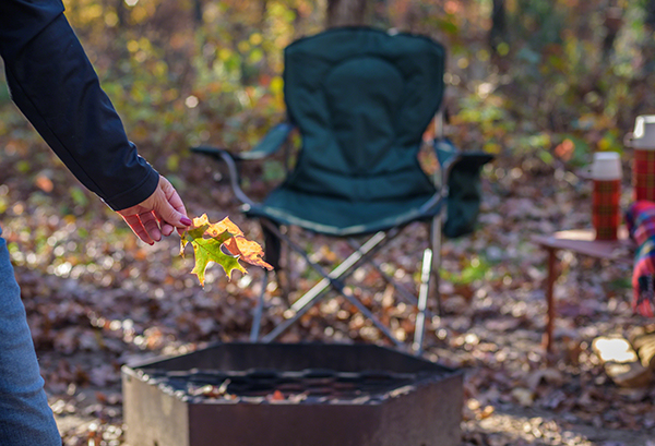 Campsite in fall, with woman holding leaves