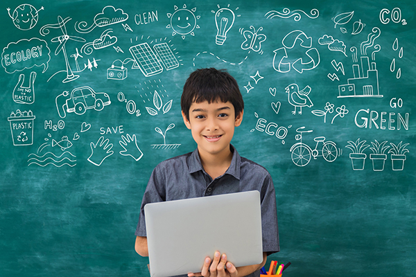 Student standing in front of blackboard with environmentally related doodles