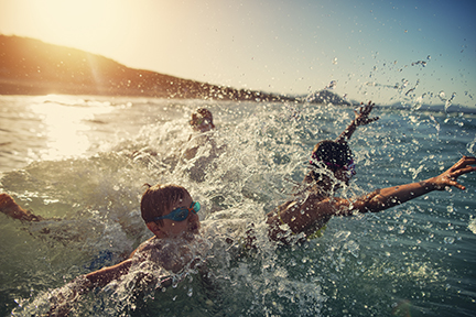 Kids jumping into incoming sea waves