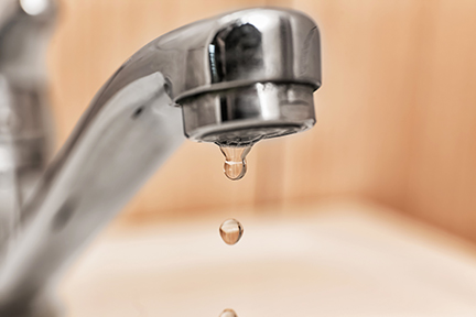 Water dripping out of the tap.