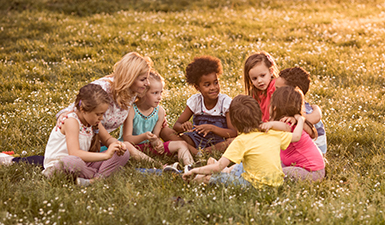 Teacher talking to group of elementary students in nature