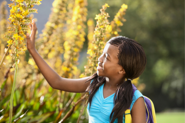 Girl walking through flower garden