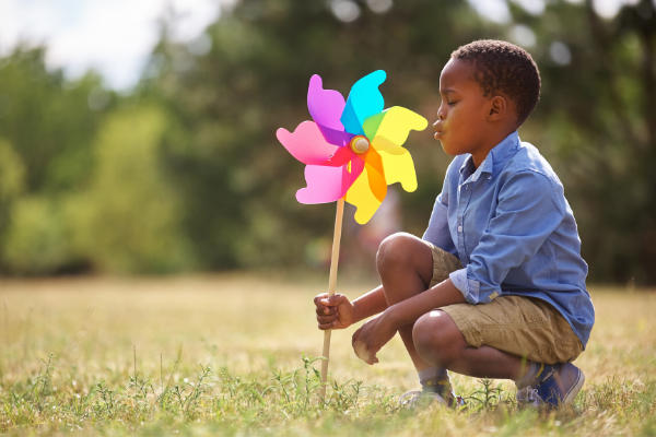 Boy blowing on pinwheel