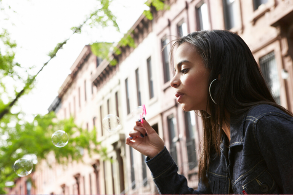 Girl blowing bubbles outside