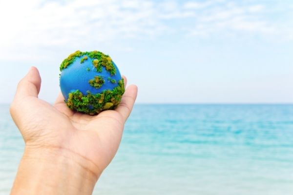 hand holder earth against an ocean background