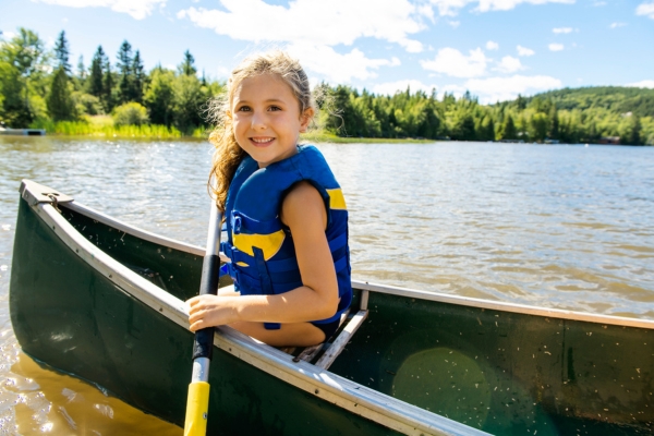 photo of a girl wearing a life jacket in a canoe