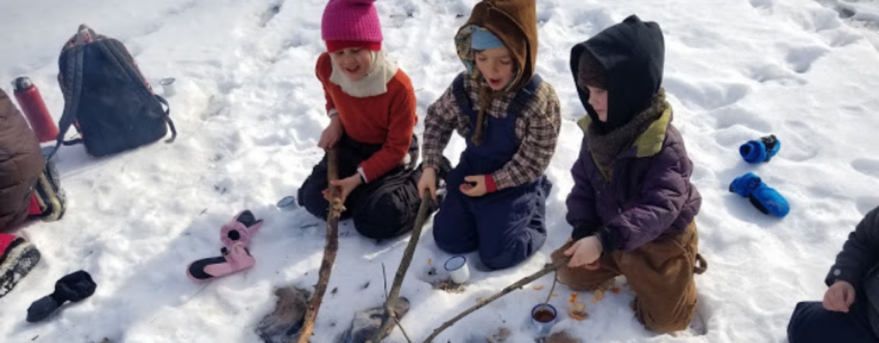 Students outside in winter around a fire